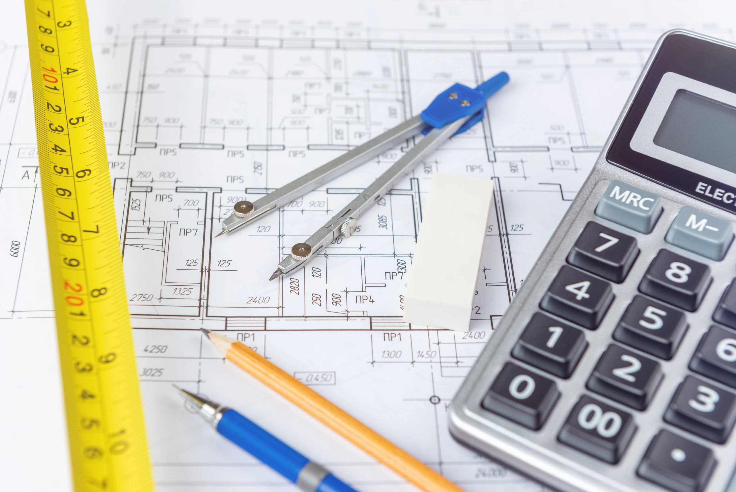 Architectural tools on a detailed blueprint layout.